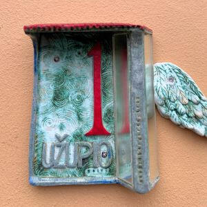 Užupio ekskursijos meniškas akcentas - keramikinė namo lentelė ant namo Nr. 1 Užupio ekskursijos meniškas akcentas: Užupio namo nr. 1 lentelė - meniškas keramikos kūrinys su veidrodėliu ir sparnu.